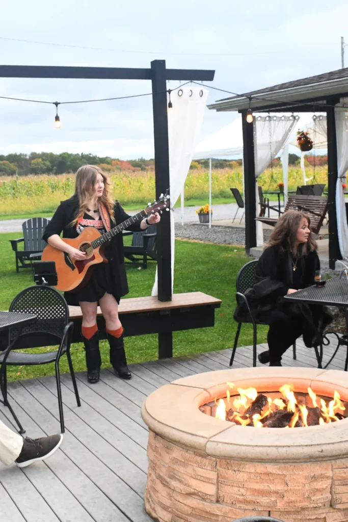 live events, woman playing a guitar at fireside delights at deer creek winery at brooks estate