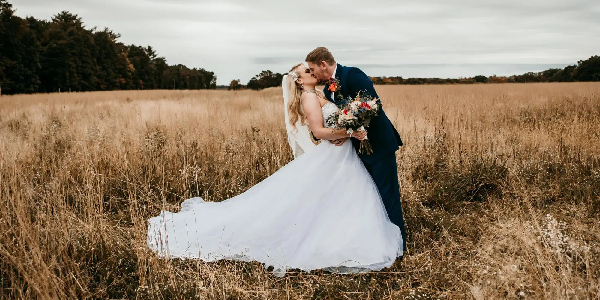 kiss in the field at a wedding at watson estate deer creek winery