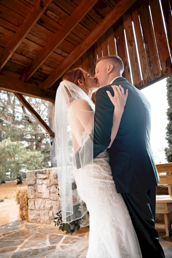 bride and groom in porch of barn
