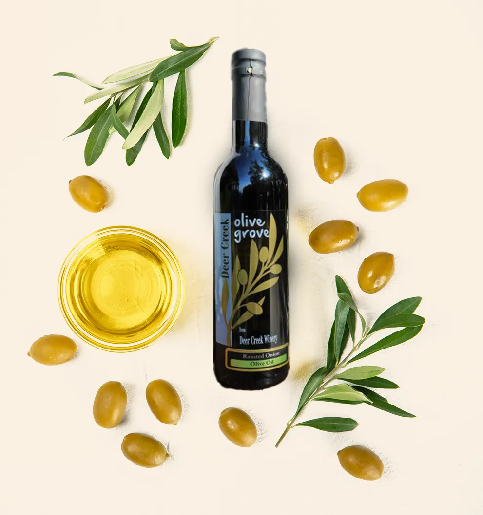 Deer Creek Winery Homepage Deer Creek Olive Grove Roasted Onion Olive Oil bottle with fresh olive branches, green olives, and a bowl of golden olive oil at Deer Creek Winery