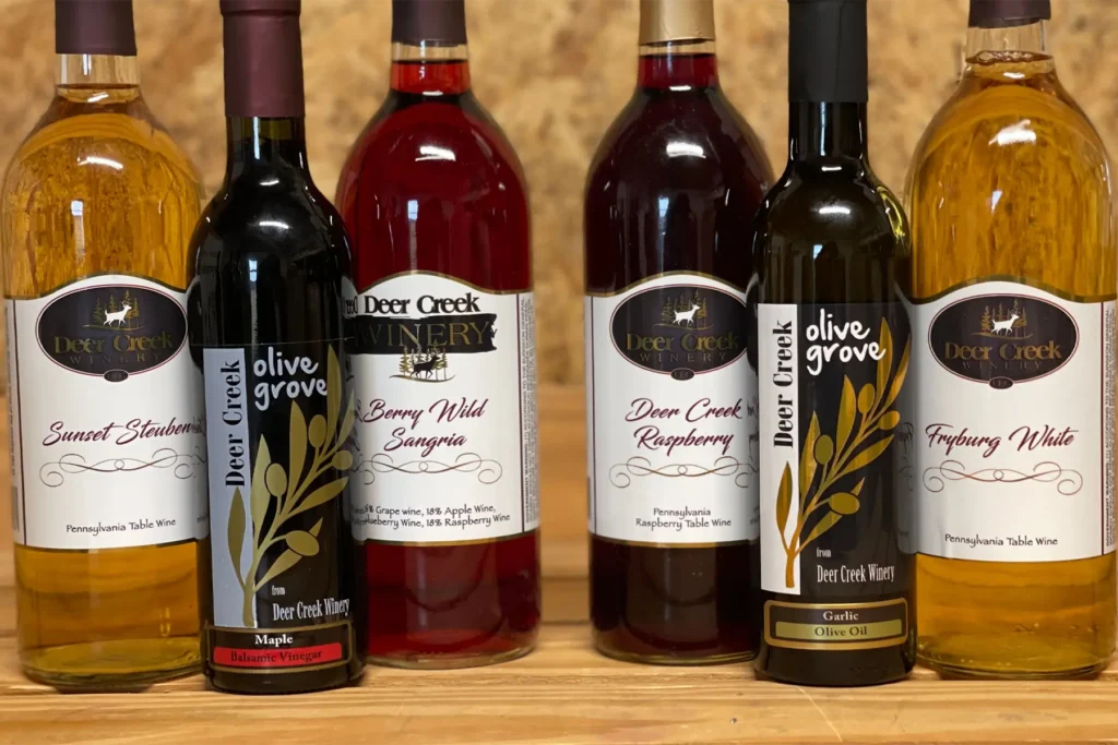 How to Build Your Own Deer Creek Wine & Food Pairing at Home Deer Creek Winery Pairing Experience lineup — Sunset Steuben, Maple Balsamic Vinegar, Berry Wild Sangria, Raspberry wine, Garlic Olive Oil, and Fryburg White