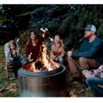 group of people sitting around a campfire at deer creek winery at brooks estate