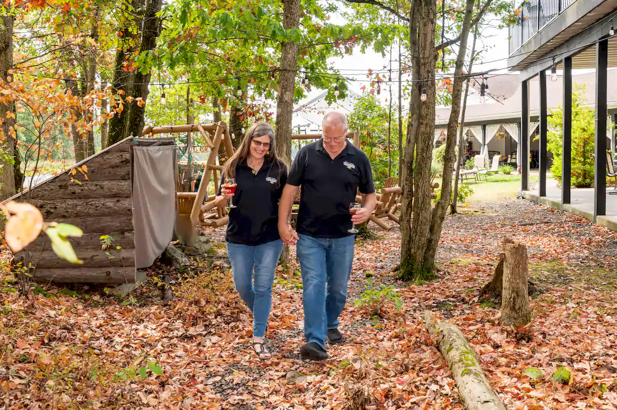 denis and rhonda brooks walking outside on leavees at brooks estate
