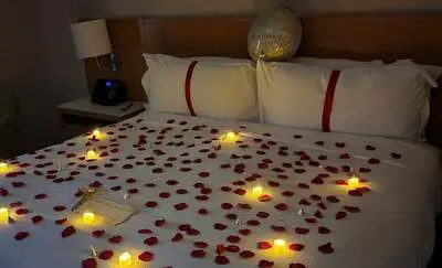 rose petals and candles on bed add on package